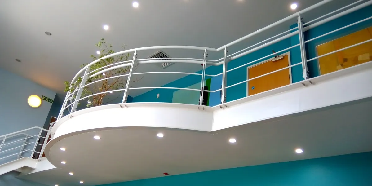 Modern interior with curved balcony and teal walls.