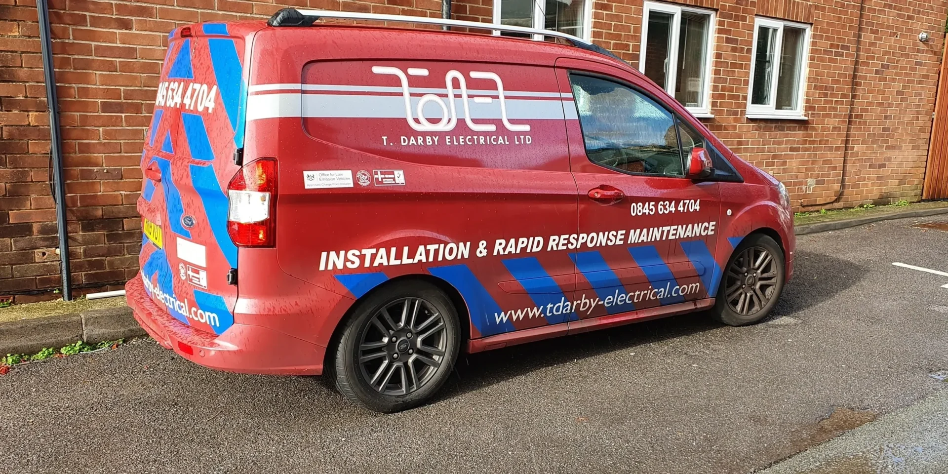 Red and blue van with company branding for installation and maintenance.